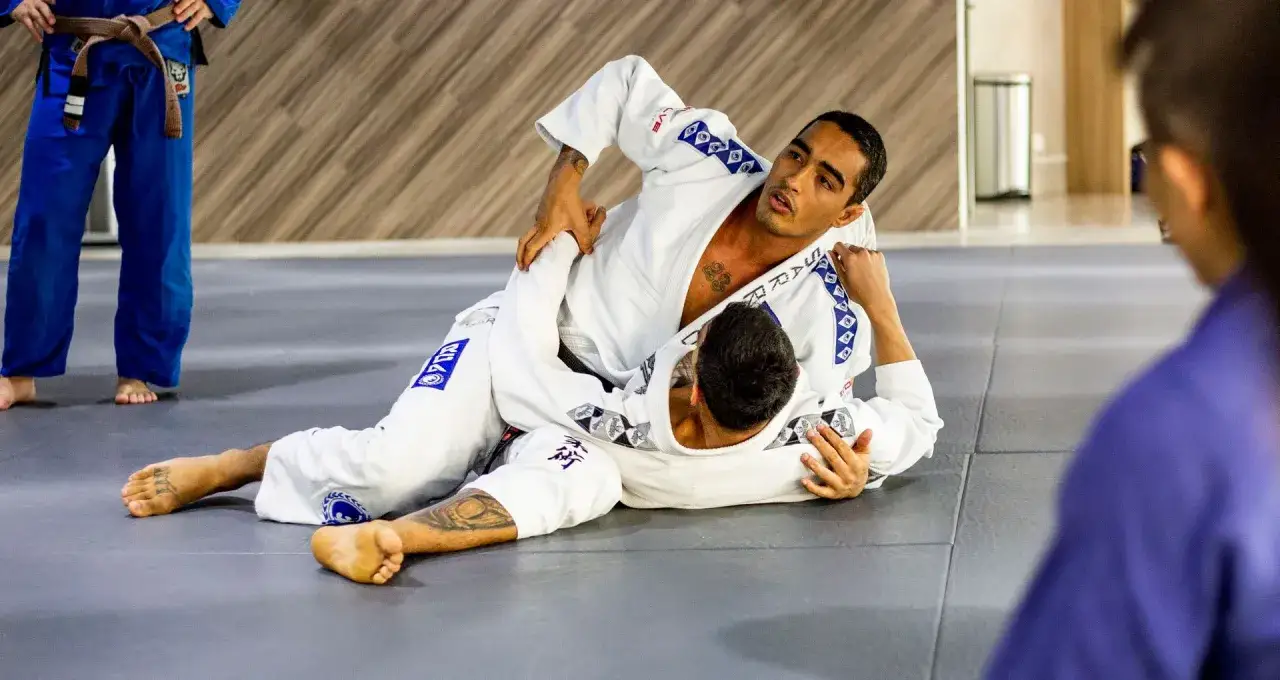 Tv&aring; m&auml;n i judodr&auml;kter tr&auml;nar en judo kast p&aring; en matta.