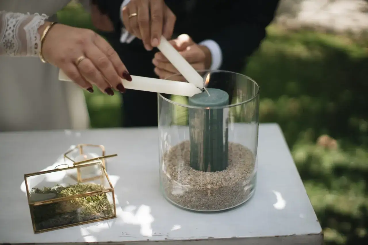 Manos encienden velas en un ritual de boda civil. Un s&iacute;mbolo de uni&oacute;n y amor eterno.