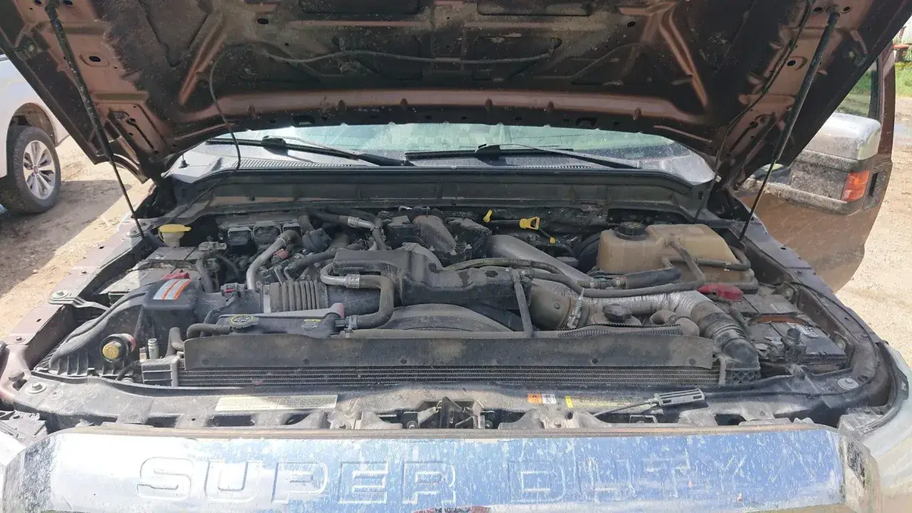 Silnik Ford F250 Super Duty, z otwartą maską, widoczne przewody i elementy chłodzenia.