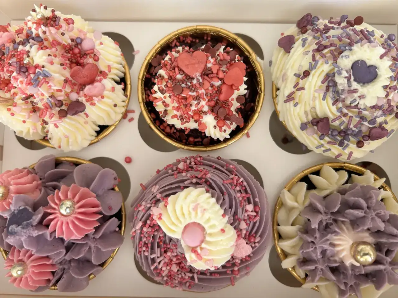 Sechs bunte Cupcakes mit Herz-Streuseln und Blumen-Dekoration. Ein tolles Rezept für jeden Anlass!