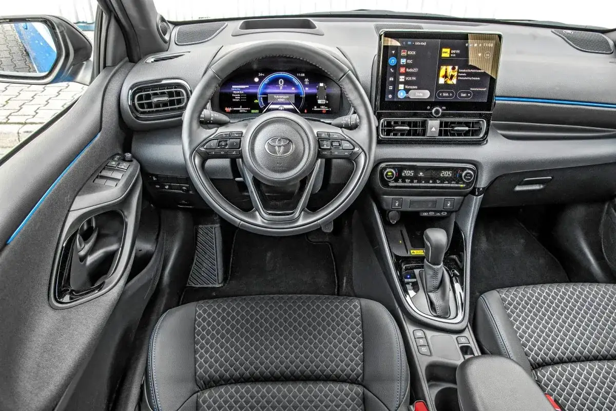 Wnętrze Toyota Yaris IV z nowoczesnym cyfrowym kokpitem, ekranem multimediów i wygodnymi fotelami.