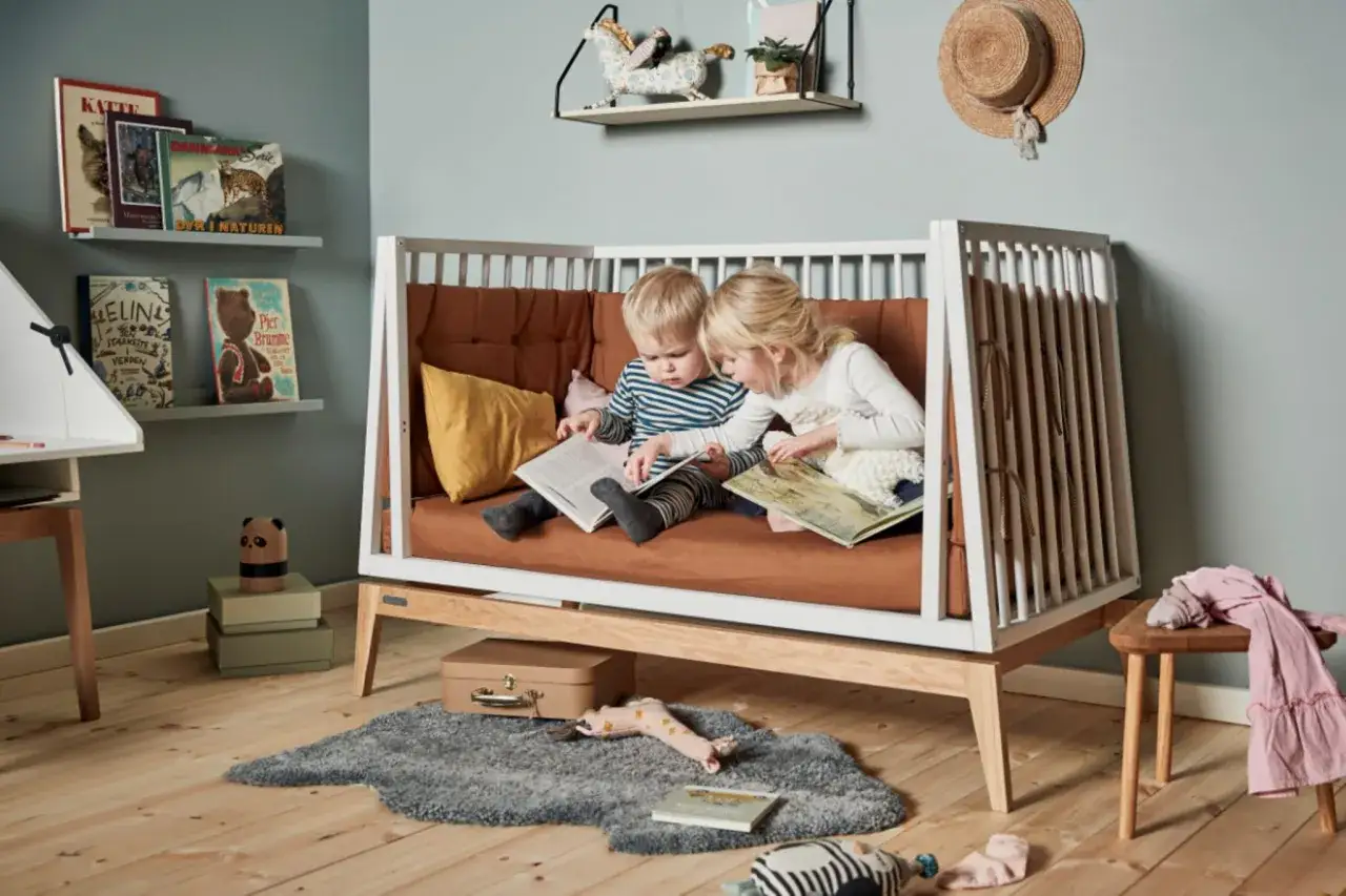 Zwei Kinder sitzen in einem Bett und lesen. Ein Junge und ein Mädchen, die gemeinsam **lesen mit Kindern** genießen, vertieft in ihre Bücher.