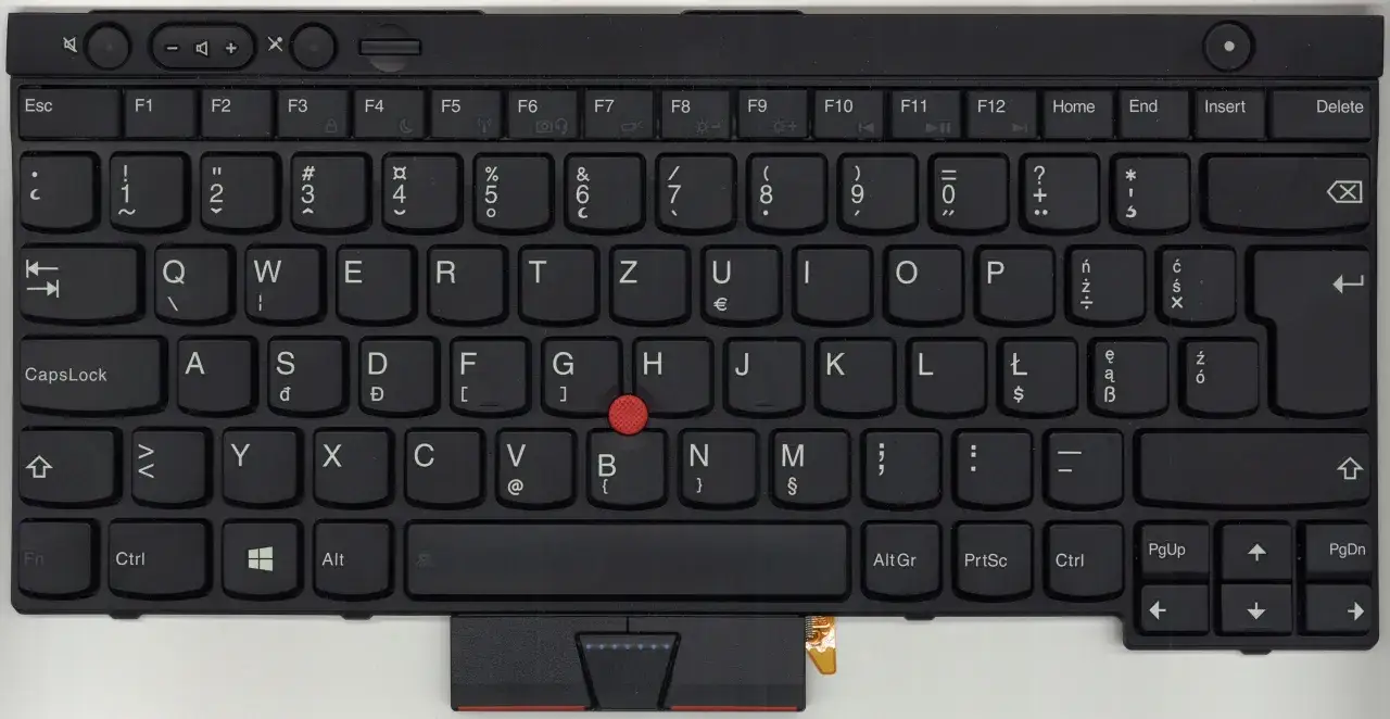 Czarna klawiatura laptopa z czerwonym trackpointem. Widoczny układ klawiatury, w tym klawisze liter, cyfr i funkcji.