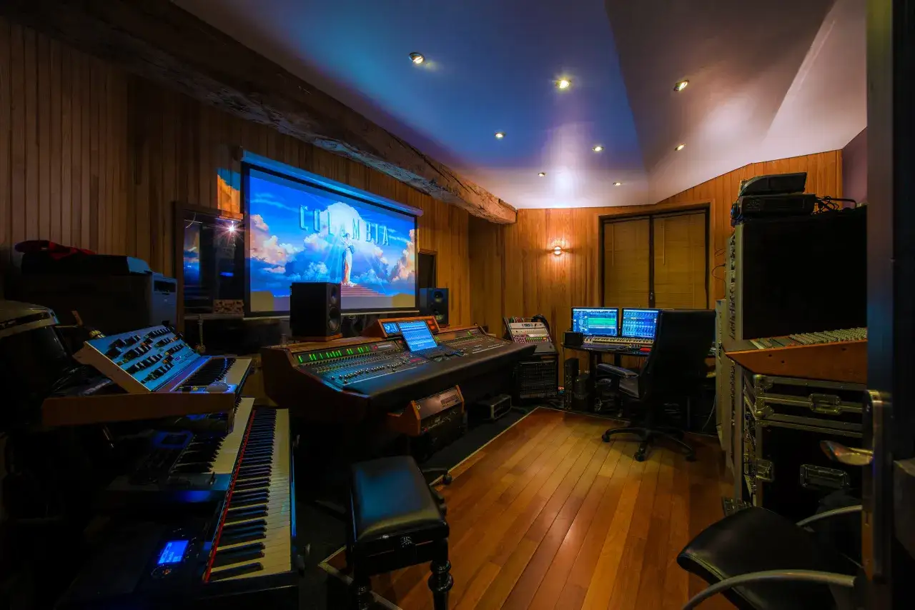 Studio d'enregistrement avec claviers, console de mixage et &eacute;cran projetant le logo Columbia. Un endroit id&eacute;al pour apprendre comment se lancer dans la musique.