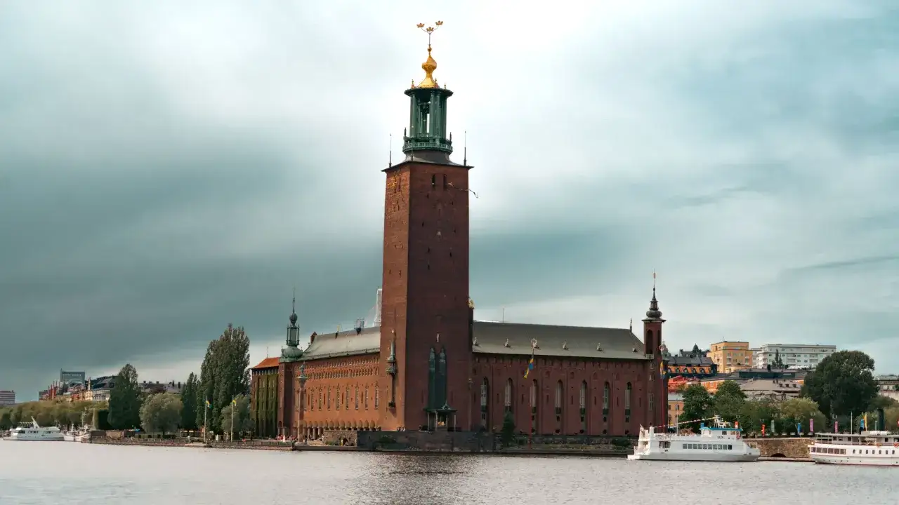 Stadshuset, ett ikoniskt landmärke att se i Stockholm, reser sig stolt vid vattnet med sitt höga torn.