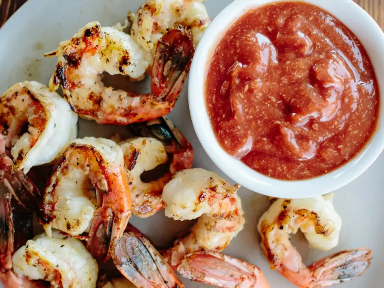 Camarones a la parrilla servidos con una generosa porci&oacute;n de salsa americana, listos para ser disfrutados.