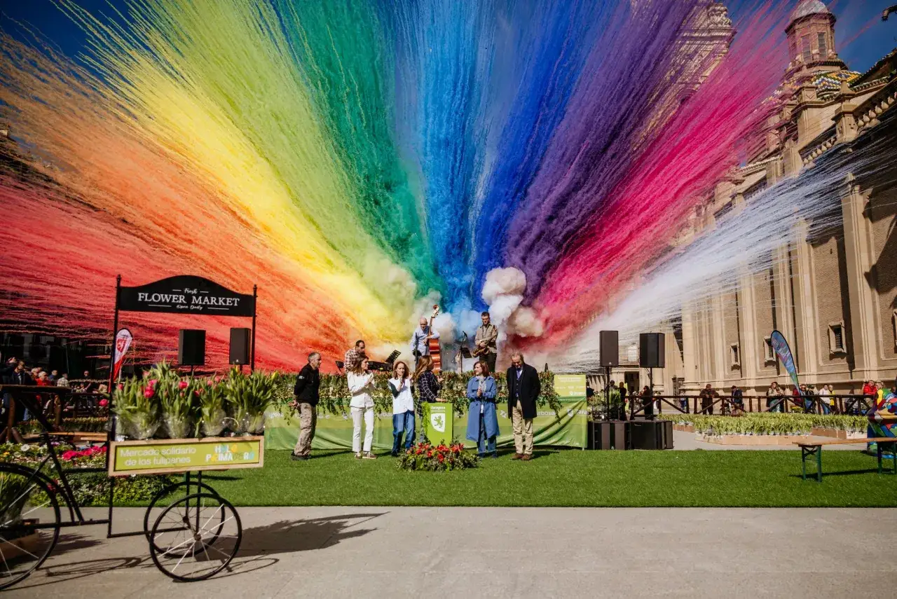 Un colorido espectáculo de confeti arcoíris celebra el Flower Market en Zaragoza. Un rastrillo Aragón con tulipanes anuncia el evento.