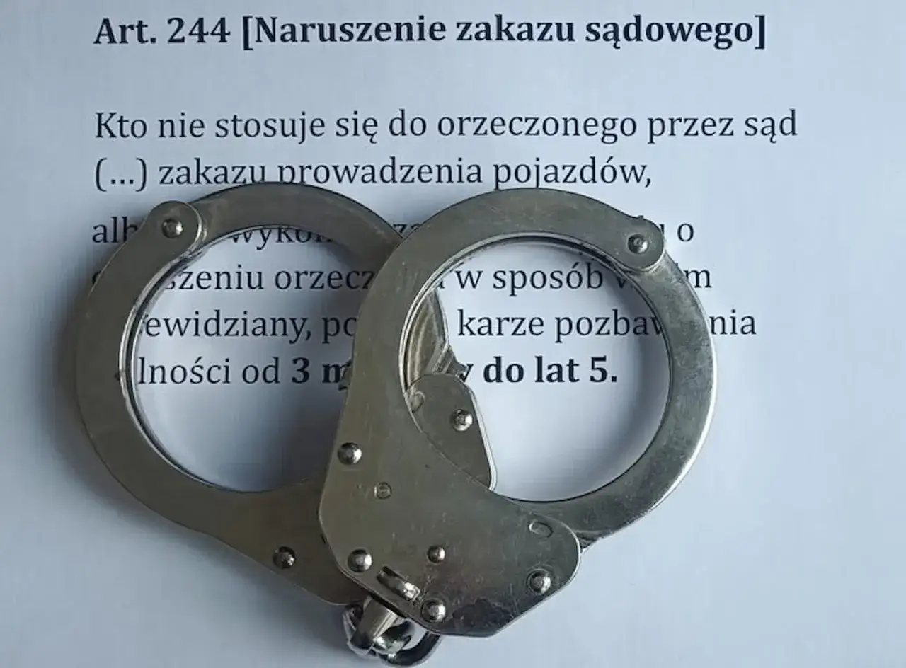 Kajdanki na dokumencie o naruszeniu zakazu sądowego, grożącym karą pozbawienia wolności do lat 5 za złamanie zakazu prowadzenia pojazdów.