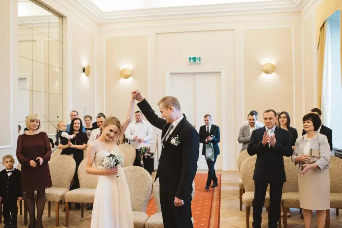 Szczęśliwa para młoda po ślubie cywilnym, goście gratulują. To nowy początek, kiedy można wziąć ślub cywilny po rozwodzie.