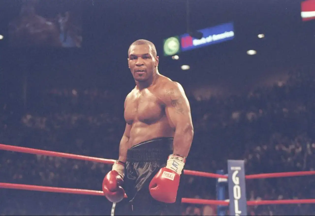 Mike Tyson in the ring, ready to fight. His physique hints at the incredible strength needed to answer how much could Mike Tyson bench.