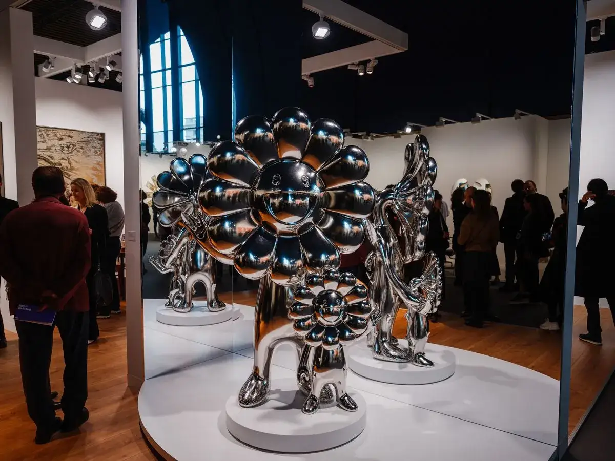 Des sculptures florales argentées, œuvres d'un artiste contemporain, captivent les visiteurs dans une galerie.
