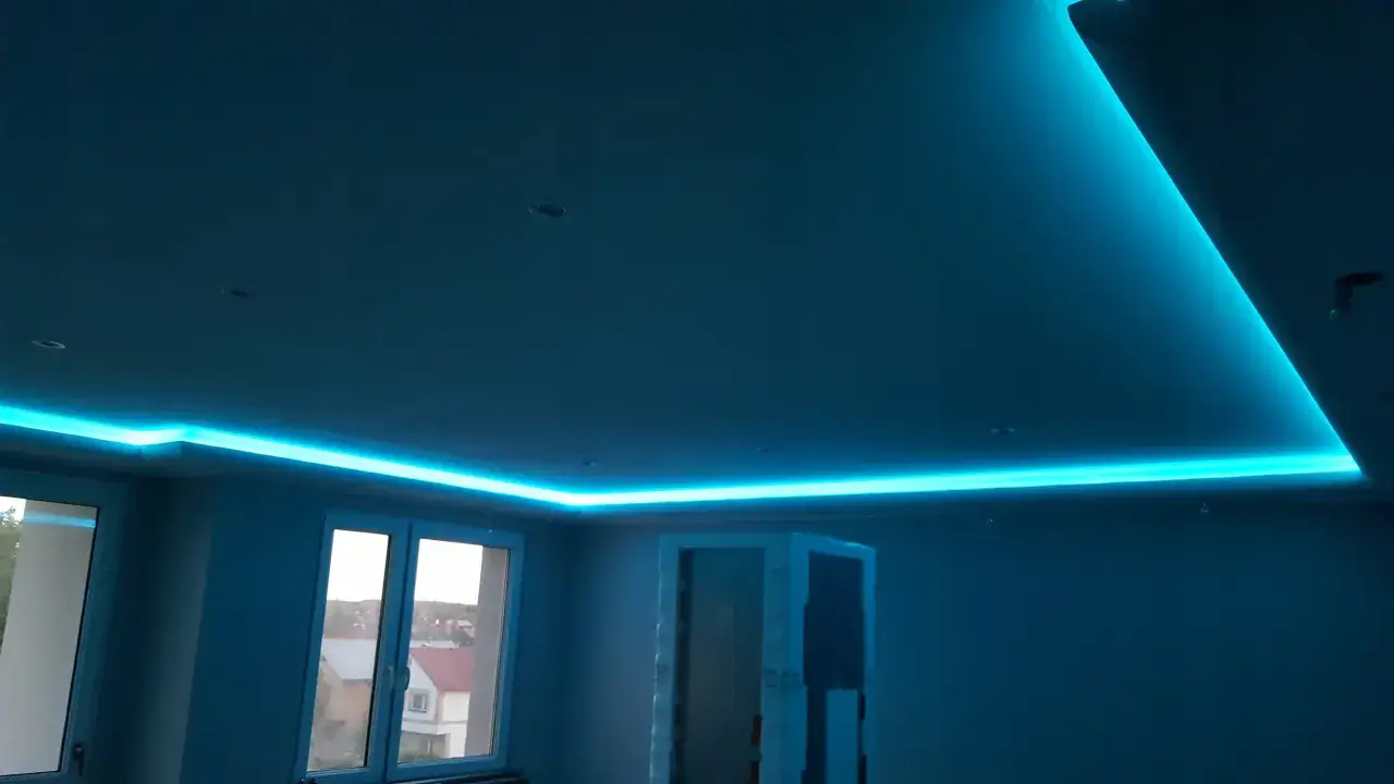Nowoczesne ozdoby na suficie w postaci niebieskiego podświetlenia LED tworzą futurystyczny klimat.