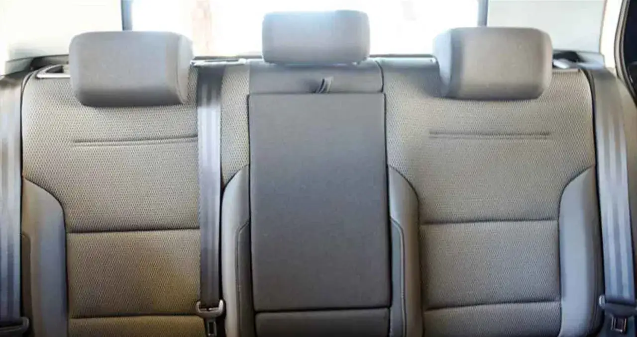 Sedili posteriori in tessuto grigio di una macchina Golf 7, con cinture di sicurezza visibili.