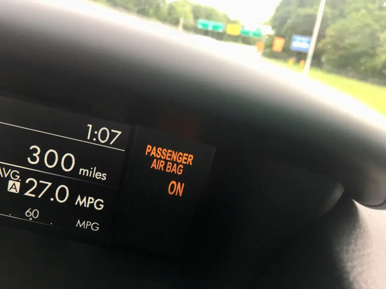The dashboard shows the passenger airbag is ON. The car has traveled 300 miles and averages 27.0 MPG.