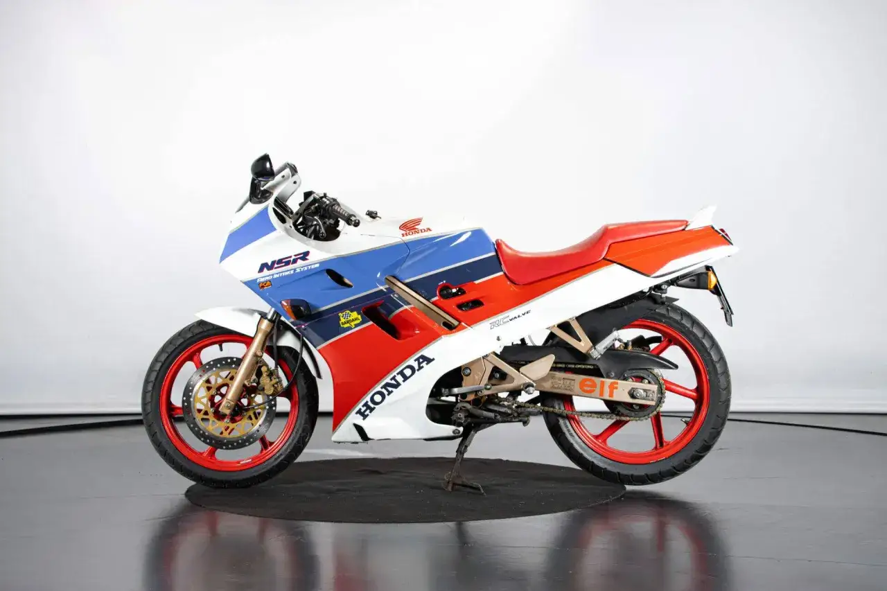 Sportowy motocykl Honda NSR 125 w biało-niebiesko-czerwonych barwach. Dane techniczne tego klasyka z pewnością zachwycą fanów.