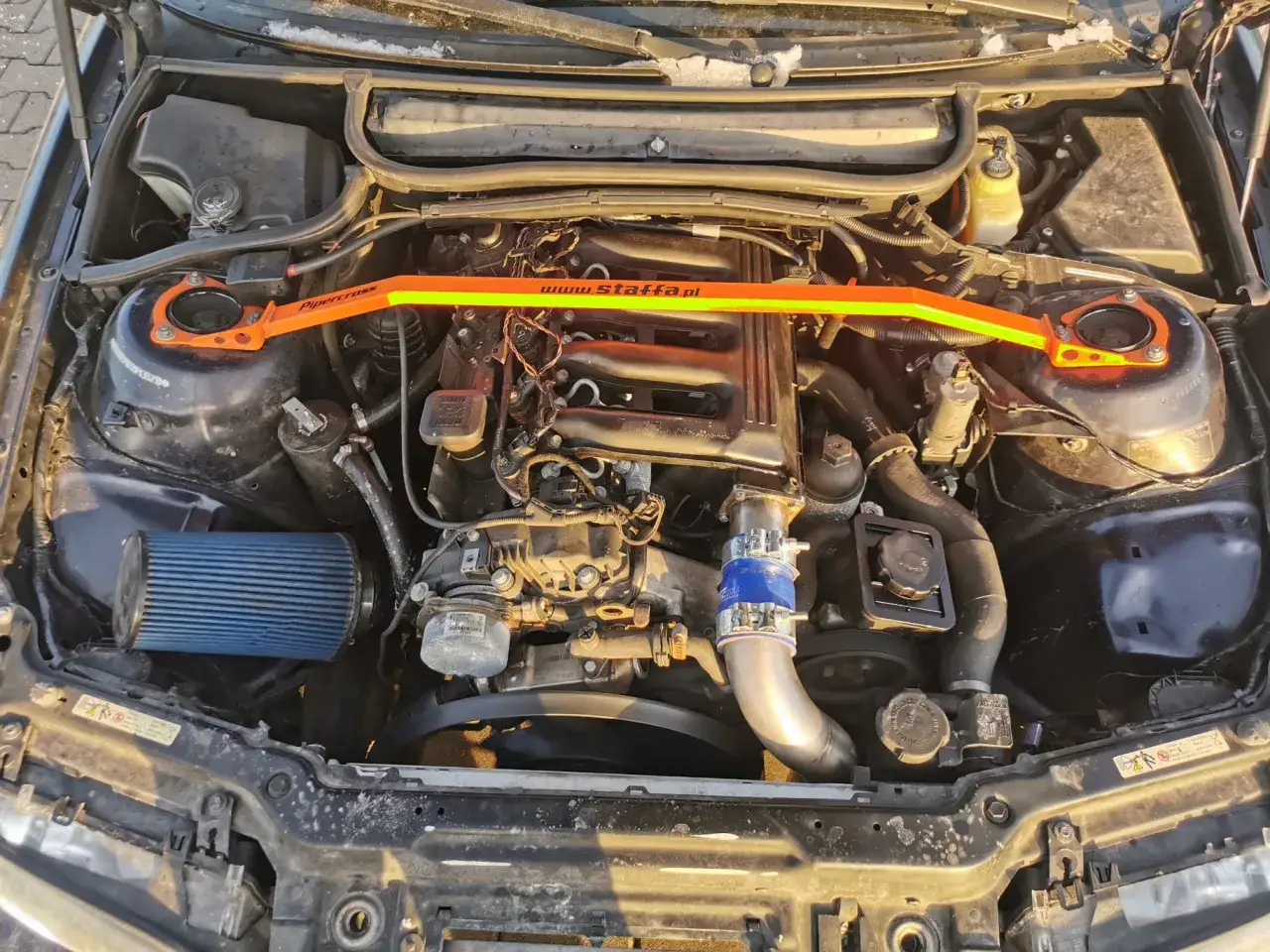 Silnik BMW E46 330d z pomarańczowym rozpórką kielichów i niebieskim filtrem stożkowym. Opinie o tym modelu są pozytywne.