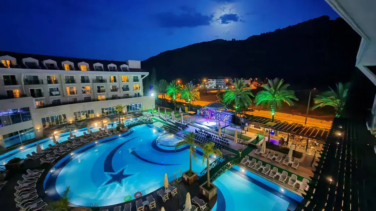 Nocny widok na basen i hotel, idealne miejsce na wakacje. Meder Resort Hotel opinie potwierdzają jego urok.