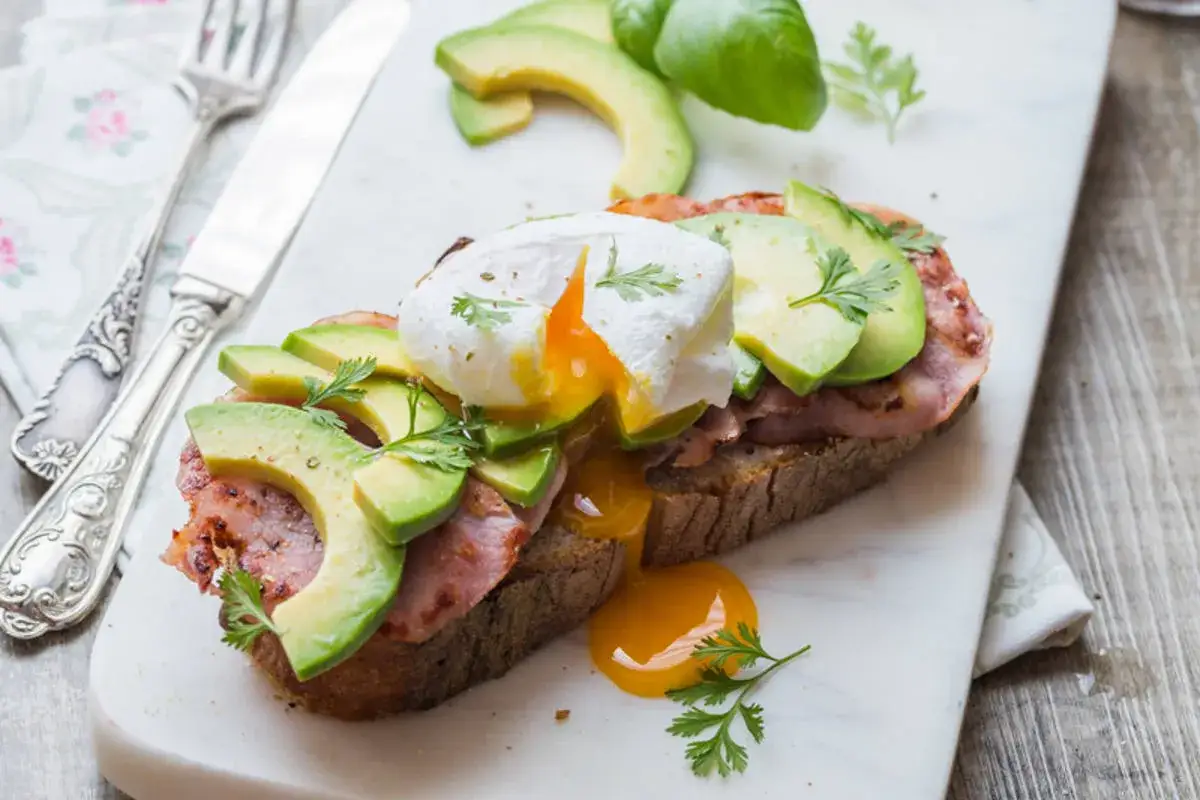 Avocado toast avec œuf poché, bacon et avocat. Une recette simple et délicieuse pour un brunch parfait.