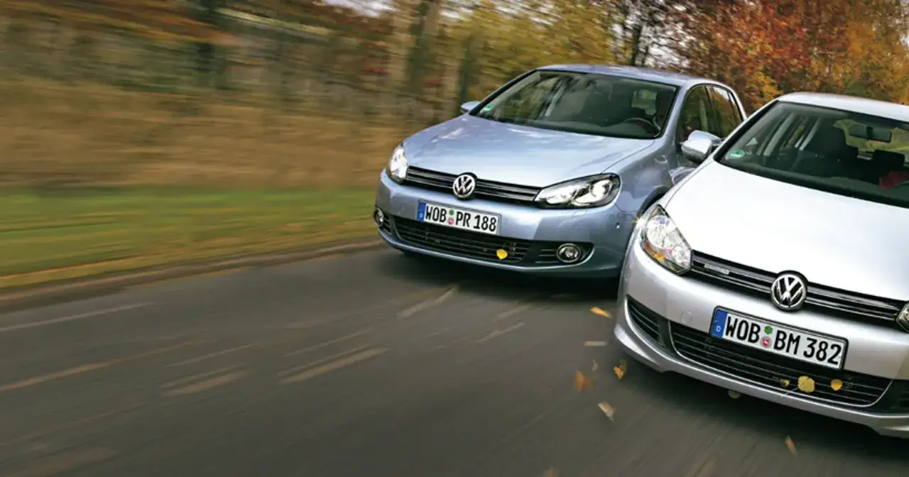Dwa Volkswageny Golf, jeden błękitny, drugi srebrny, jadące po drodze. Co oznacza bluemotion? To technologia oszczędzania paliwa.