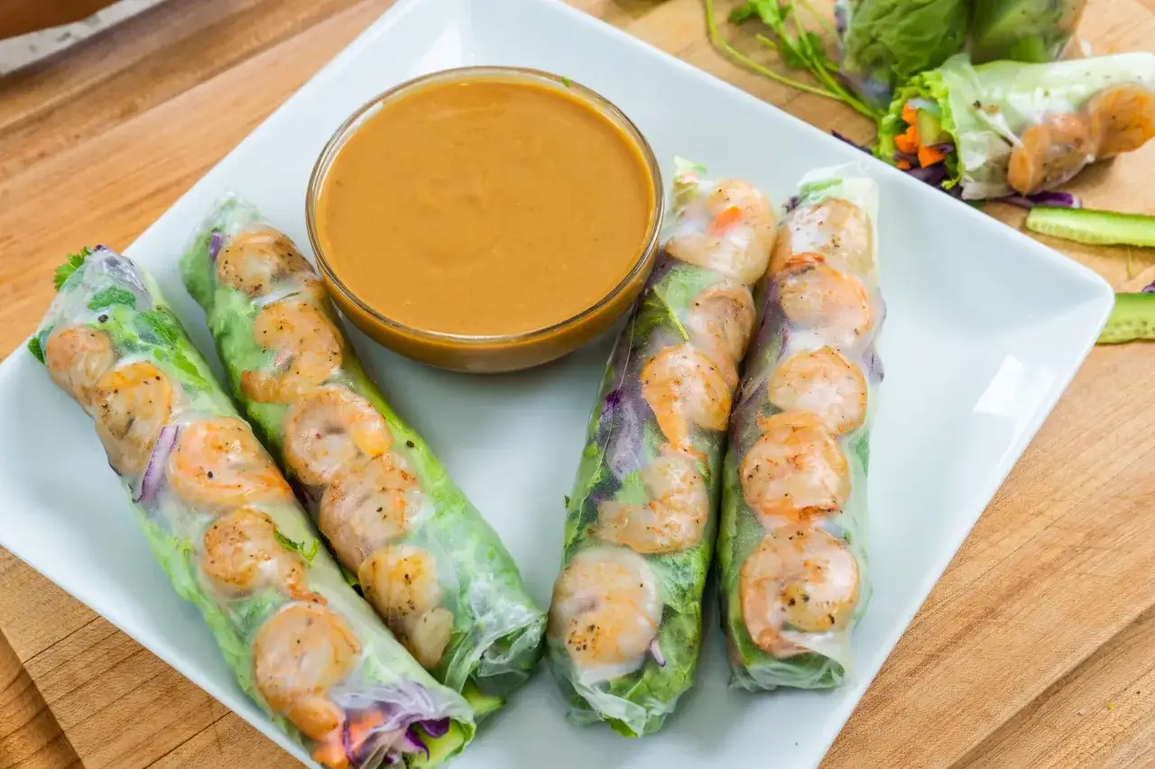 Frische low carb sommerrollen mit Garnelen und Gemüse, serviert mit Erdnusssauce. Ein leichter Genuss für warme Tage.