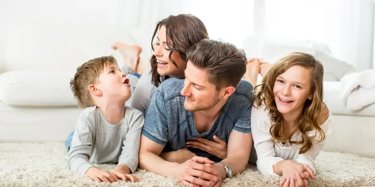 Famille heureuse avec deux enfants, profitant d'un moment de complicité. L'allocation familiale pour 2 enfants leur permet de vivre ces instants précieux.