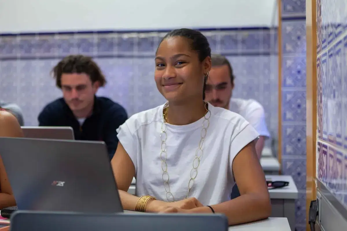 Estudiante sonr&iacute;e en clase, prepar&aacute;ndose para sus dobles grados con relaciones internacionales.
