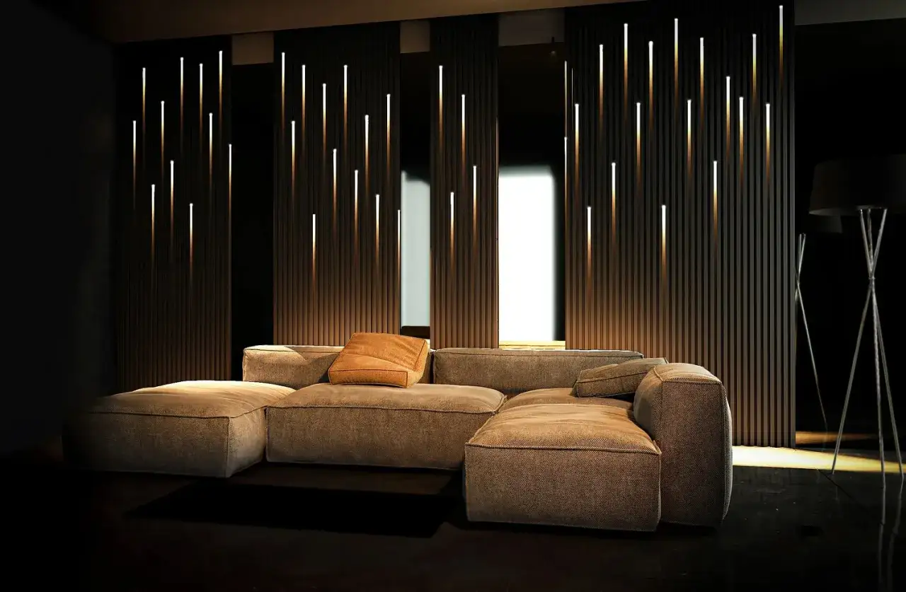 Un salon moderne avec un canap&eacute; confortable et un mur orn&eacute; de fines lumi&egrave;res verticales, cr&eacute;ant une ambiance chaleureuse gr&acirc;ce &agrave; une dalle led design.