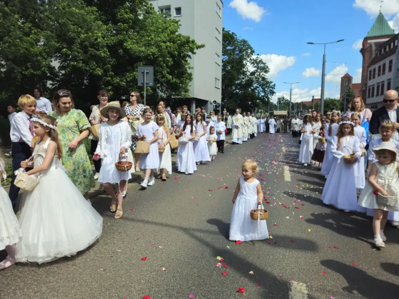 Dzieci w białych strojach sypią kwiaty podczas procesji. Czy to już Boże Ciało 2026? Kiedy?