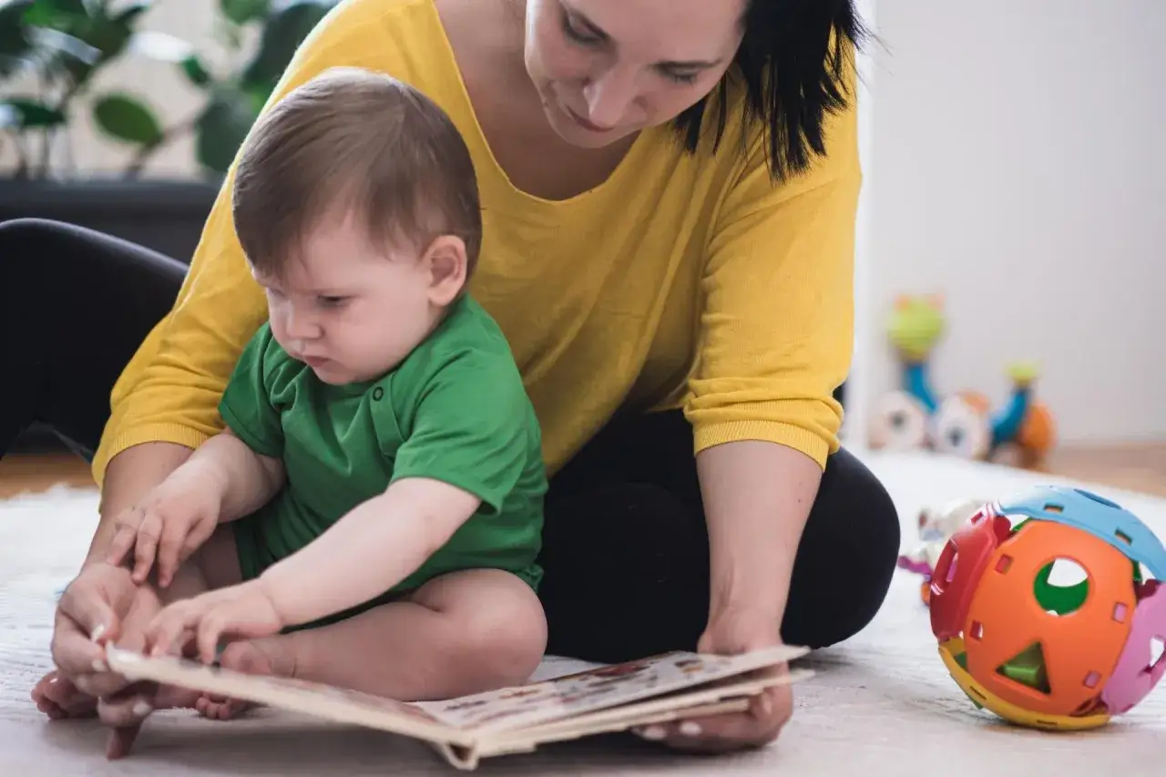 Mama czyta dziecku książeczkę. Dofinansowanie do żłobka komu przysługuje? Sprawdź, czy Twoja rodzina się kwalifikuje.