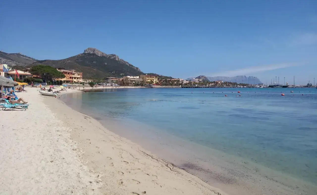 Plage de sable fin, eaux turquoises et montagnes en arrière-plan. Un rêve sarde, un coin de paradis pour se détendre.