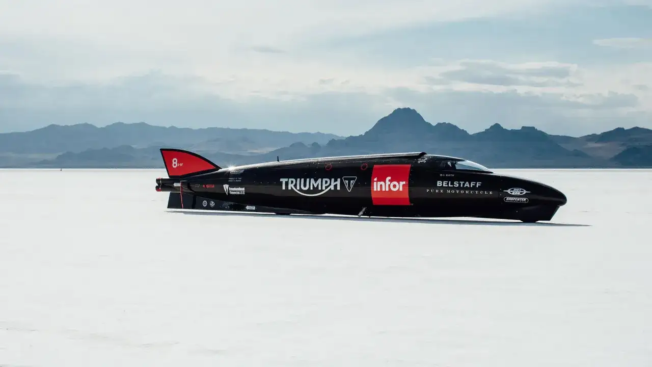 Czarny, opływowy motocykl Triumph na pustyni Bonneville, być może najszybszy motor na świecie, gotowy do bicia rekordów.