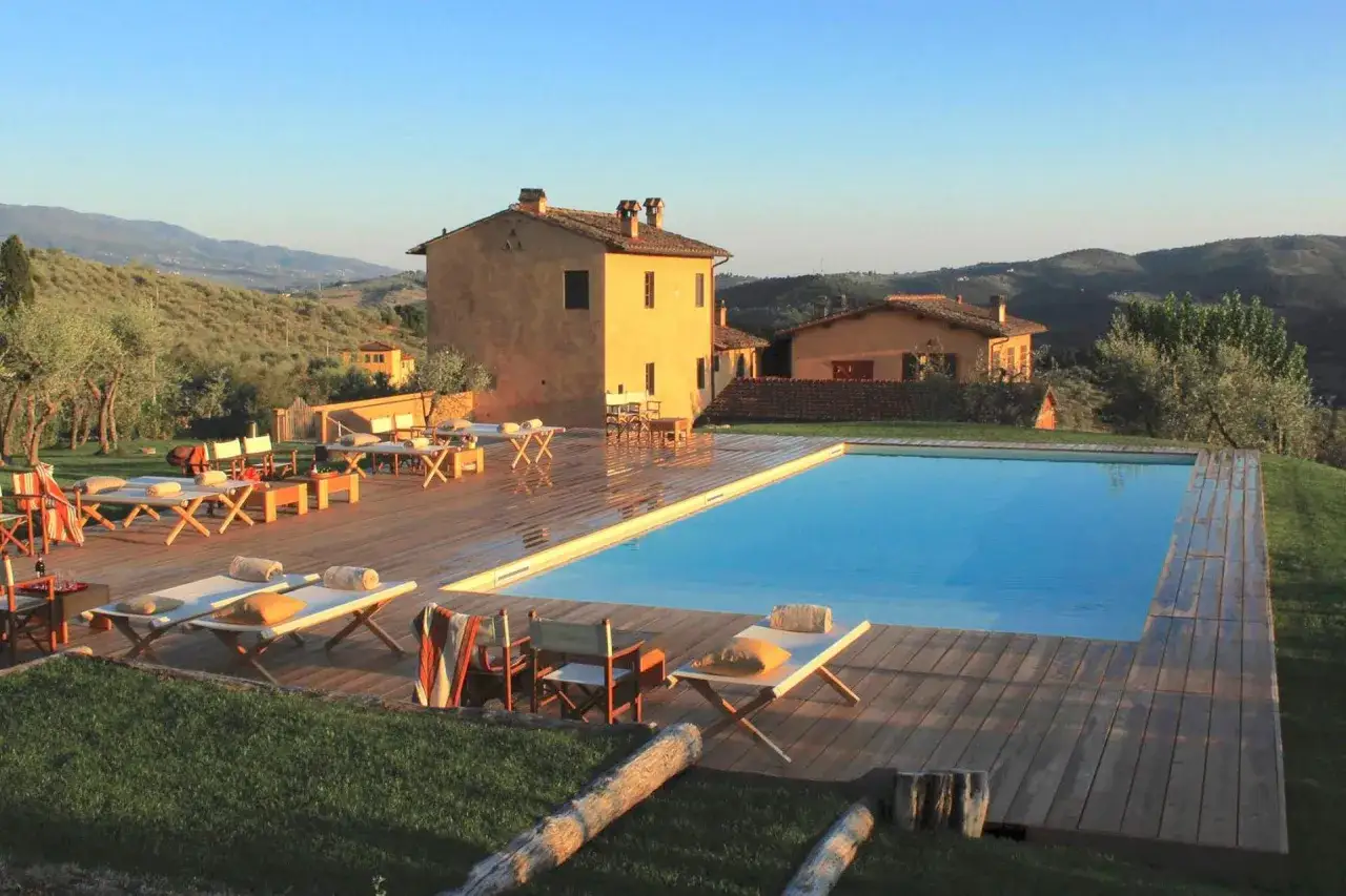 Piscina e lettini in un agriturismo toscano, ideale per vacanze tranquille ad agosto in Italia.
