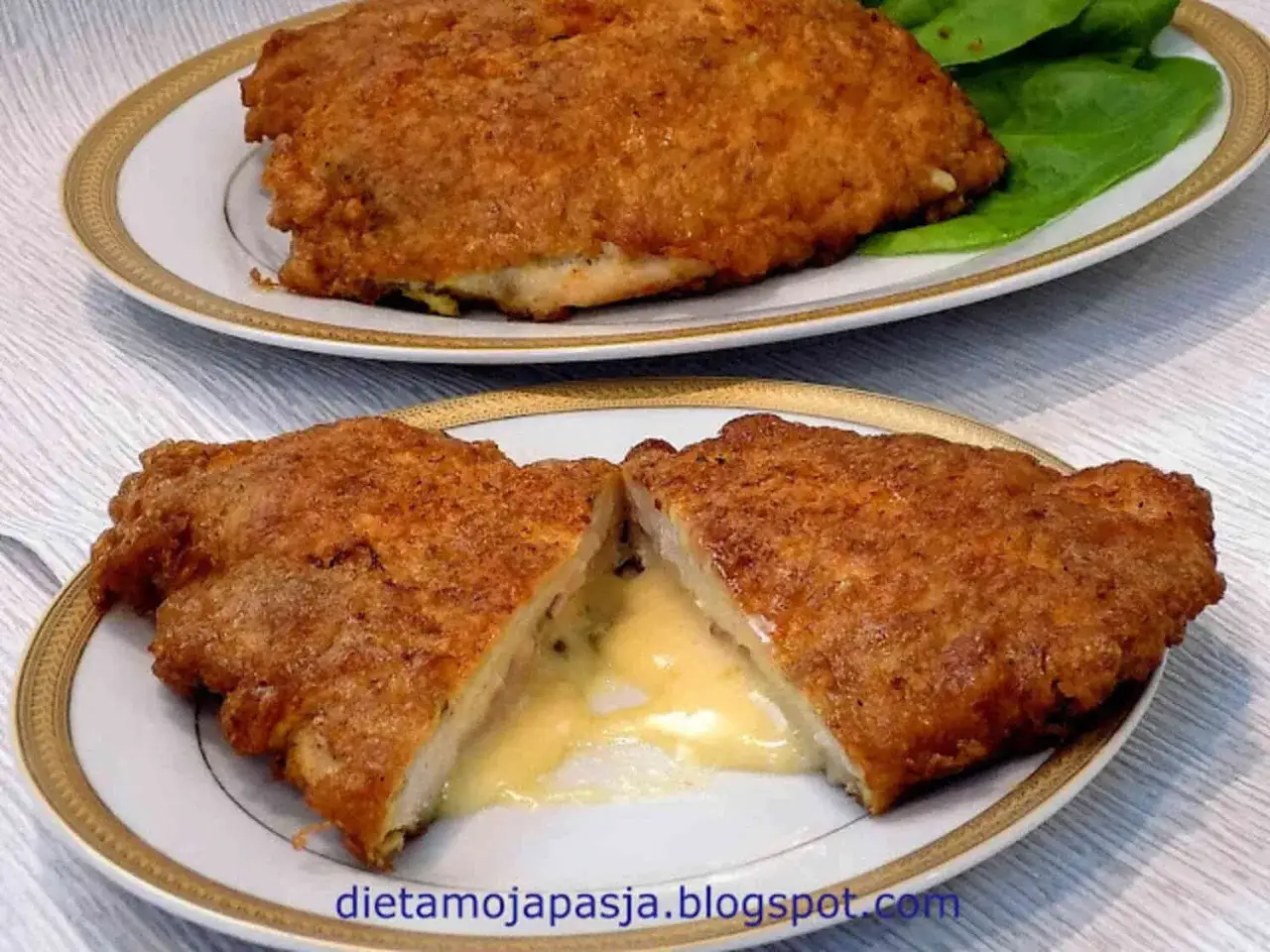 Pyszny kotlet po szwajcarsku, rozpływający się ser w środku, podany na talerzu z zielonymi liśćmi.