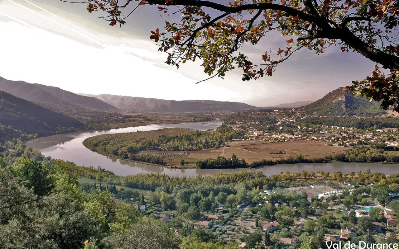 Vue panoramique d'une vall&eacute;e avec une rivi&egrave;re sinueuse, des collines et un village. Id&eacute;al pour une randonn&eacute;e &agrave; Pertuis.