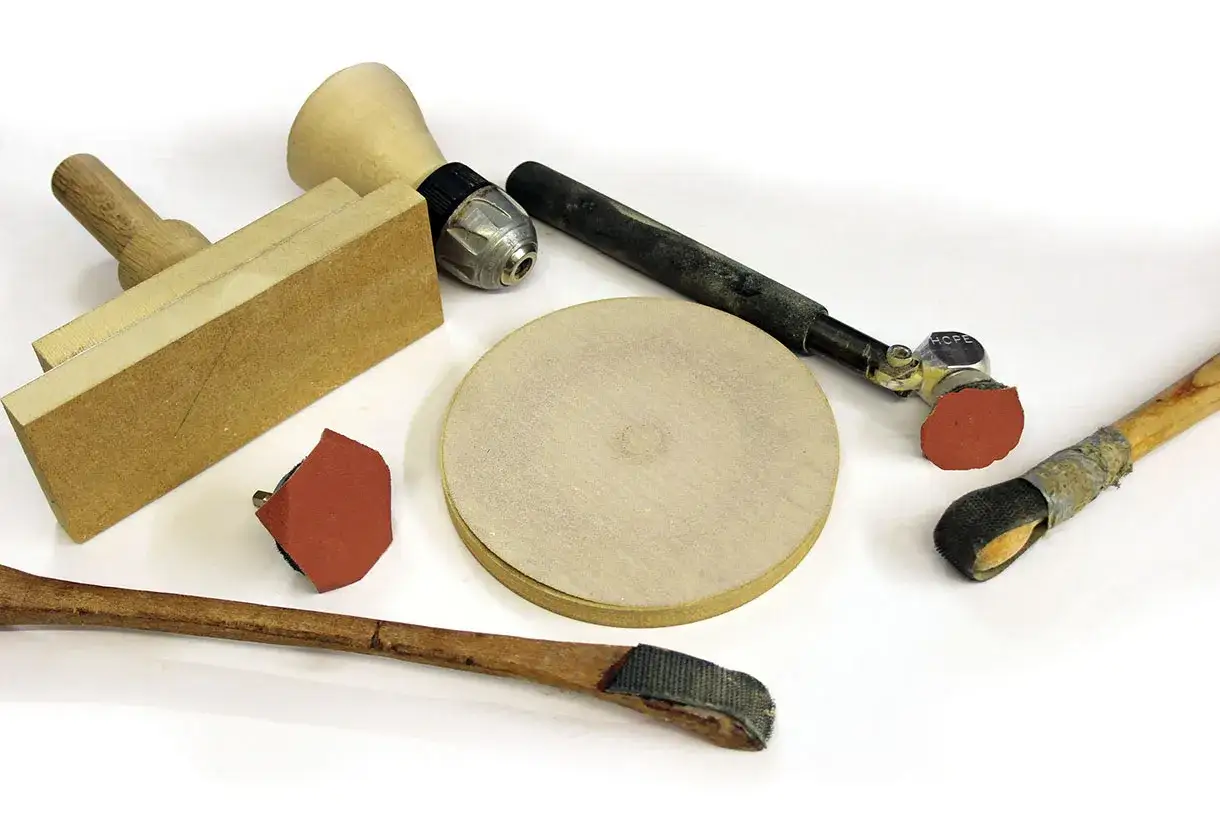 Ensemble d'outils pour le pon&ccedil;age bois : bloc, disques, et accessoires rotatifs pour un travail de finition pr&eacute;cis.