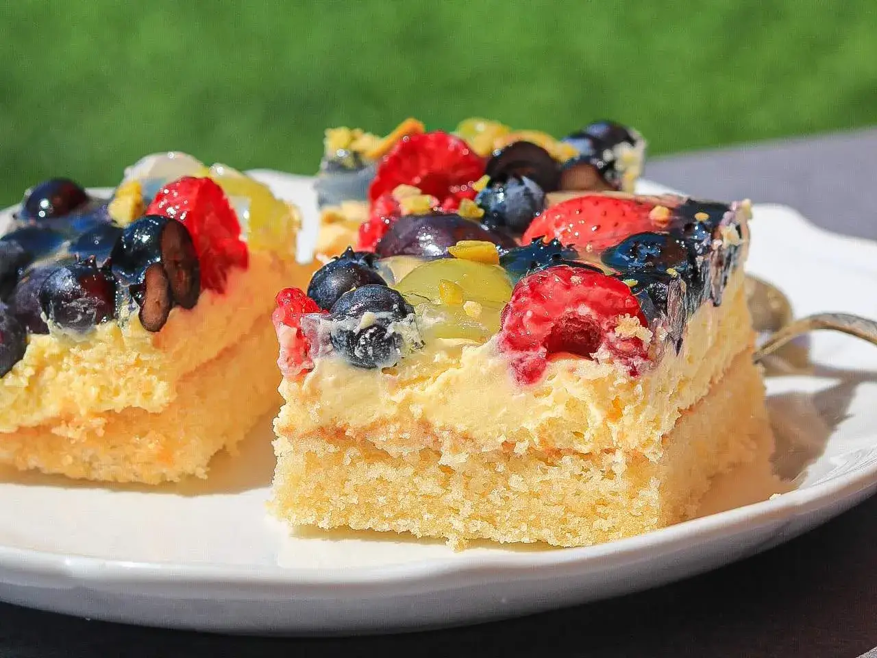 Saftiger Blechkuchen mit Obst, belegt mit Blaubeeren, Erdbeeren und Trauben. Ein Genuss für jeden Anlass.