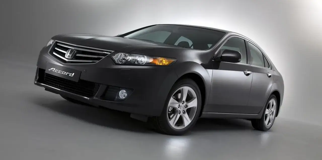 Elegancki, ciemnoszary sedan Honda Accord, jedna z wielu generacji tego popularnego modelu, prezentuje się na tle studyjnym.