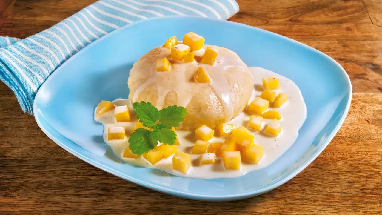 Ein fluffiger Dampfnudel-Klo&szlig; mit Vanillesauce, garniert mit Mango-W&uuml;rfeln und Minze. Ein k&ouml;stliches Rezept f&uuml;r s&uuml;&szlig;e Momente.