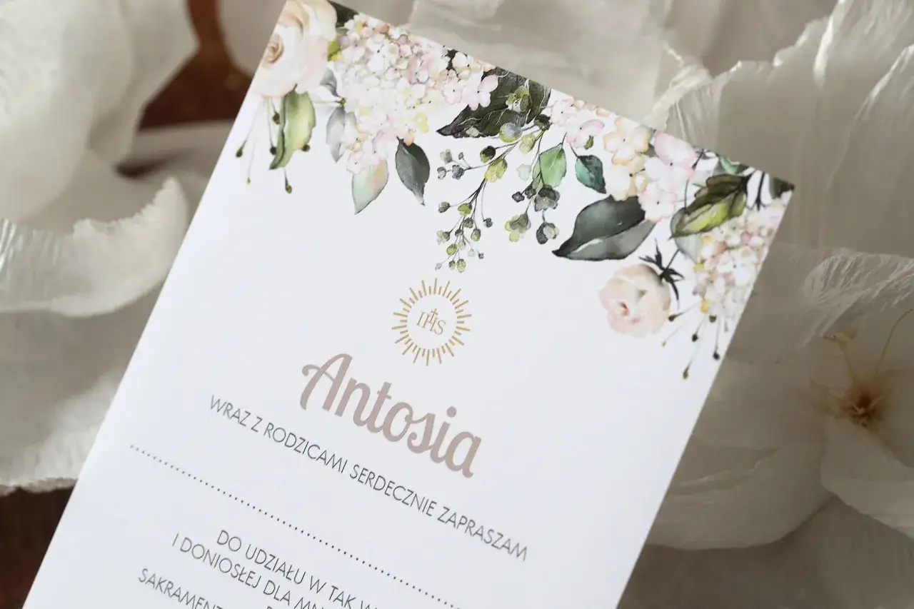 Eleganckie zaproszenie na komunię z imieniem Antosia i motywem kwiatowym. Idealne, by dowiedzieć się, jak zrobić zaproszenie na komunię w Wordzie.