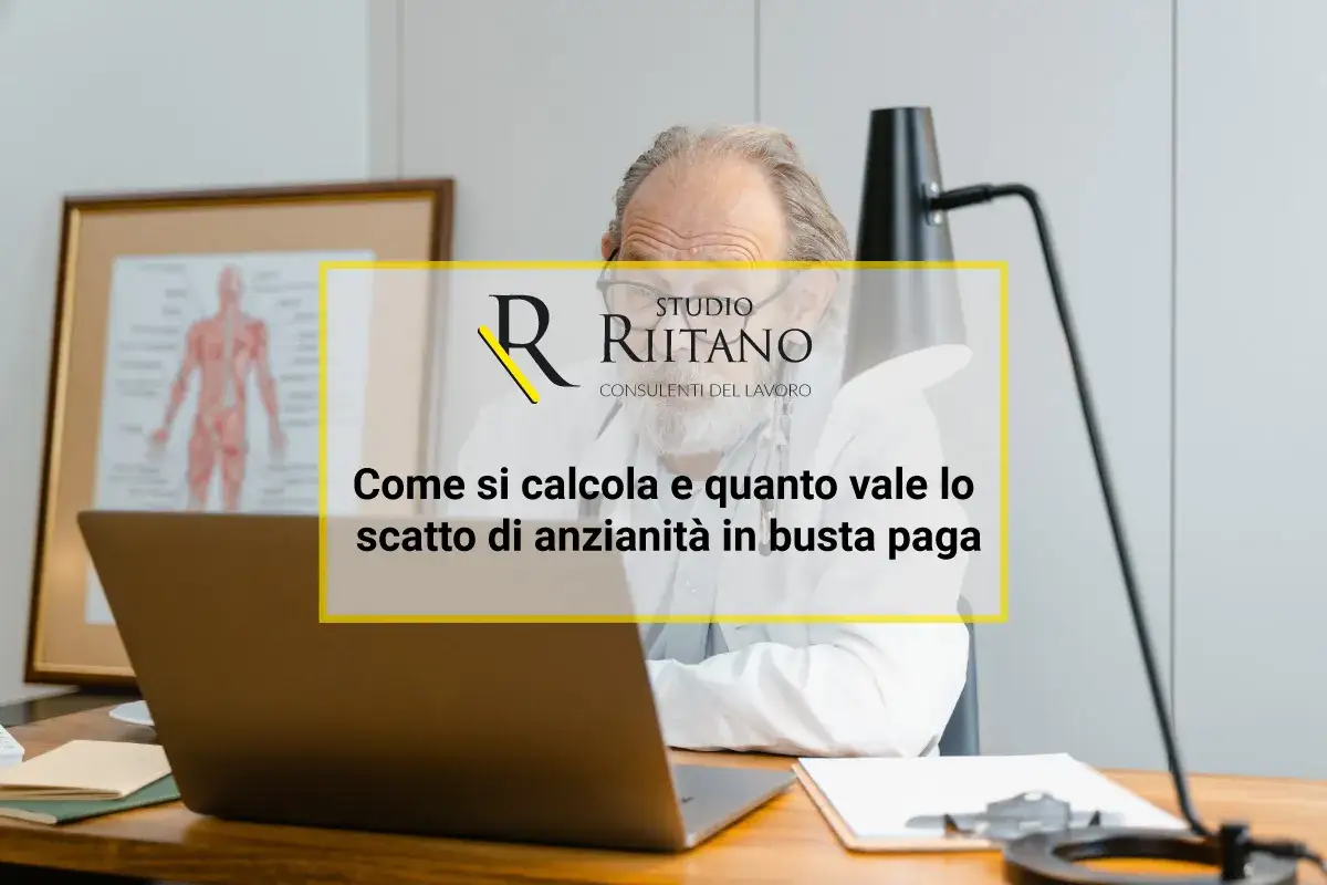 Un uomo anziano al computer studia come calcolare gli scatti di anzianità in busta paga.
