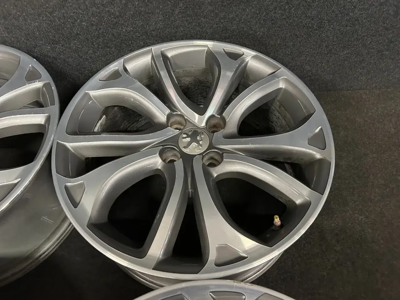 Felgi aluminiowe do Peugeot 2008 GT, w kolorze grafitowym, z pięcioramiennym wzorem.