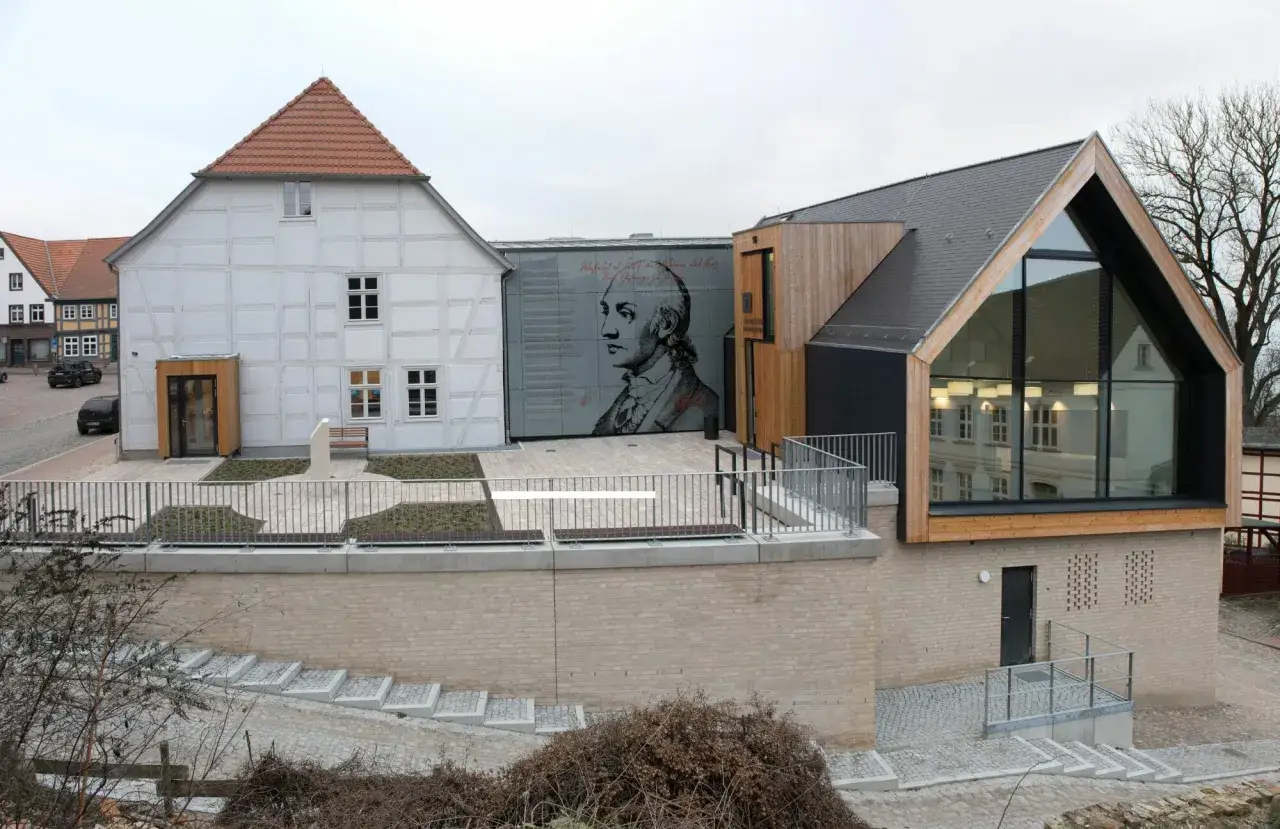 Moderne Architektur trifft auf historische Fassade. Eine gro&szlig;fl&auml;chige Darstellung eines Mannes ziert die Wand aus Faserzement.