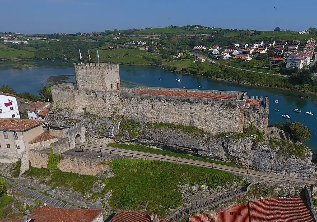 El **castillo de San Vicente de la Barquera** se alza imponente sobre un acantilado, vigilando la r&iacute;a y el pintoresco pueblo c&aacute;ntabro.