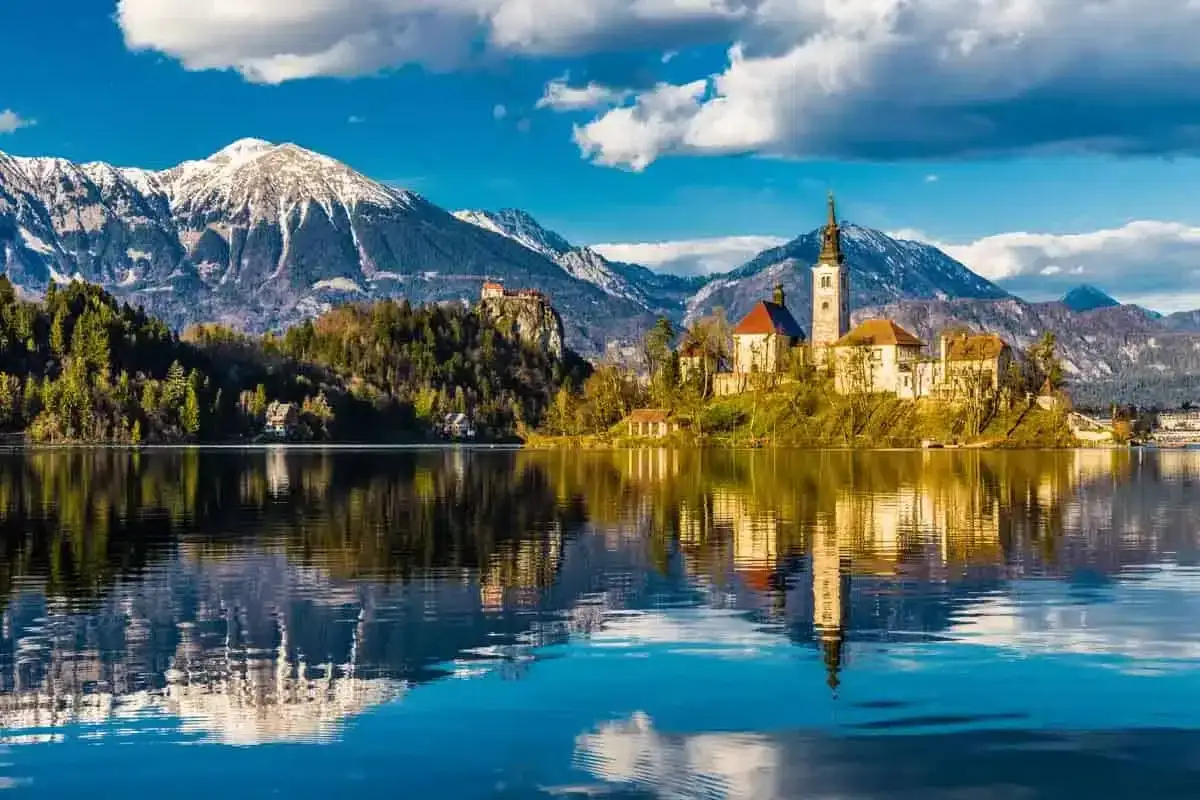 Bleder See mit Inselkirche und Burg, ein slowenisches Must-See. Majest&auml;tische Berge spiegeln sich im ruhigen Wasser.