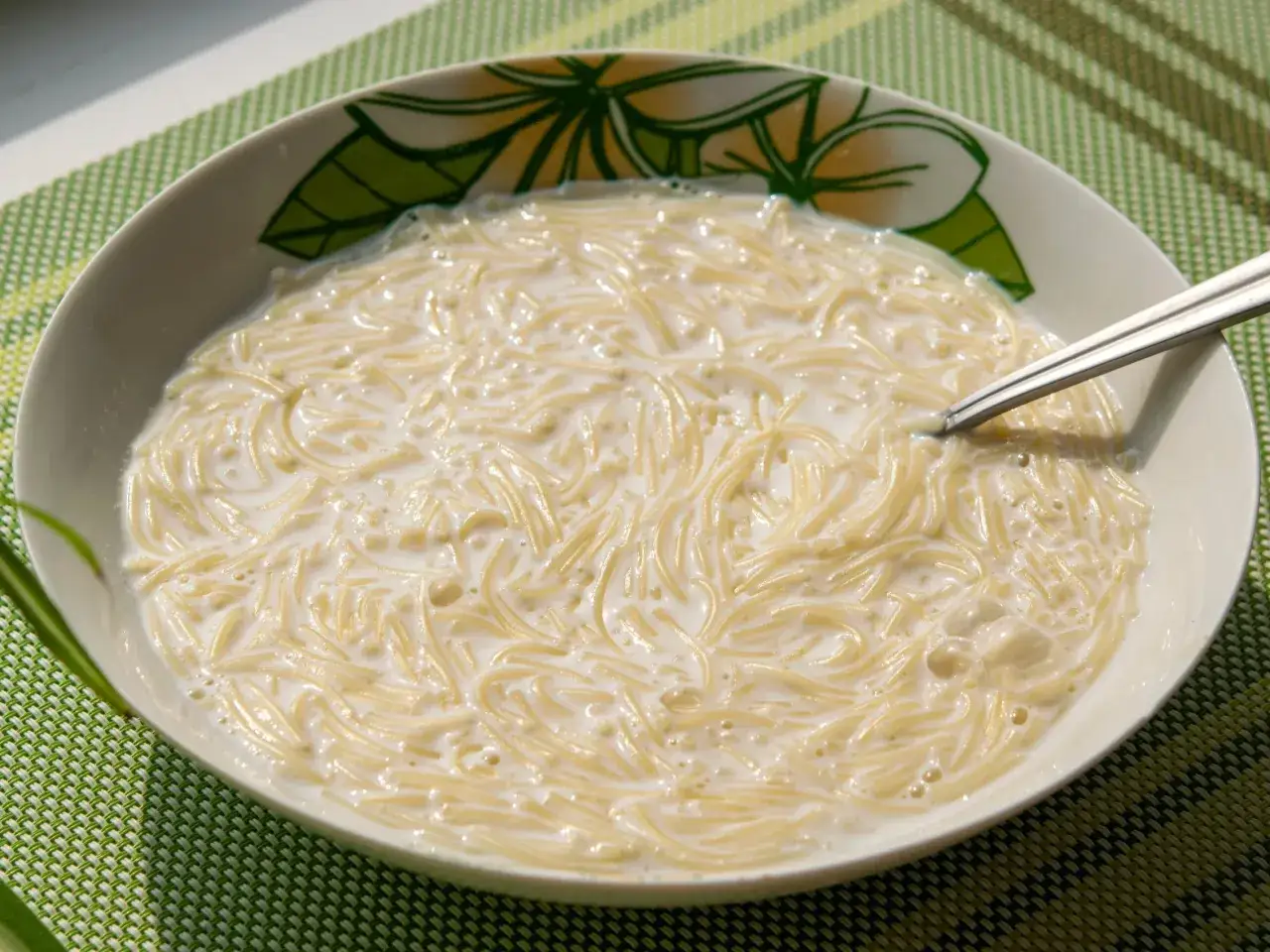 Miseczka pełna delikatnego makaronu do rosołu w mleku, gotowa do zjedzenia.