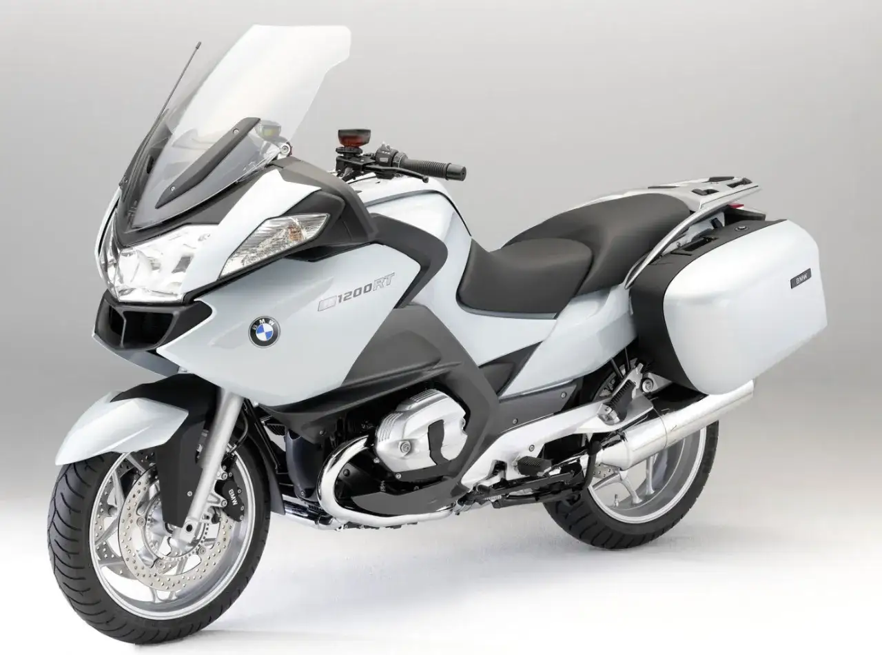Biały motocykl turystyczny BMW R 1200 RT z kuframi, gotowy na dalekie podróże.