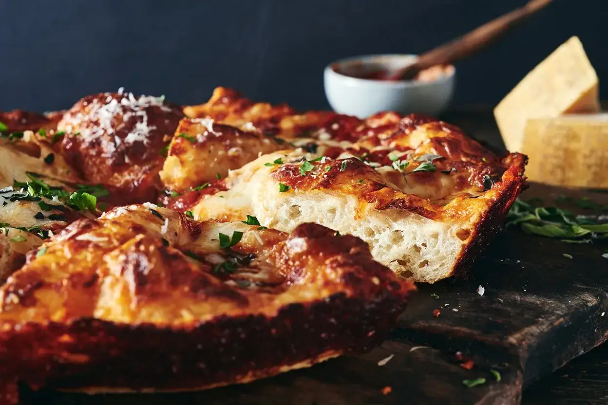 Pyszna pizza z mozzarellą, gorąca i parująca, z chrupiącym ciastem i aromatycznymi ziołami.
