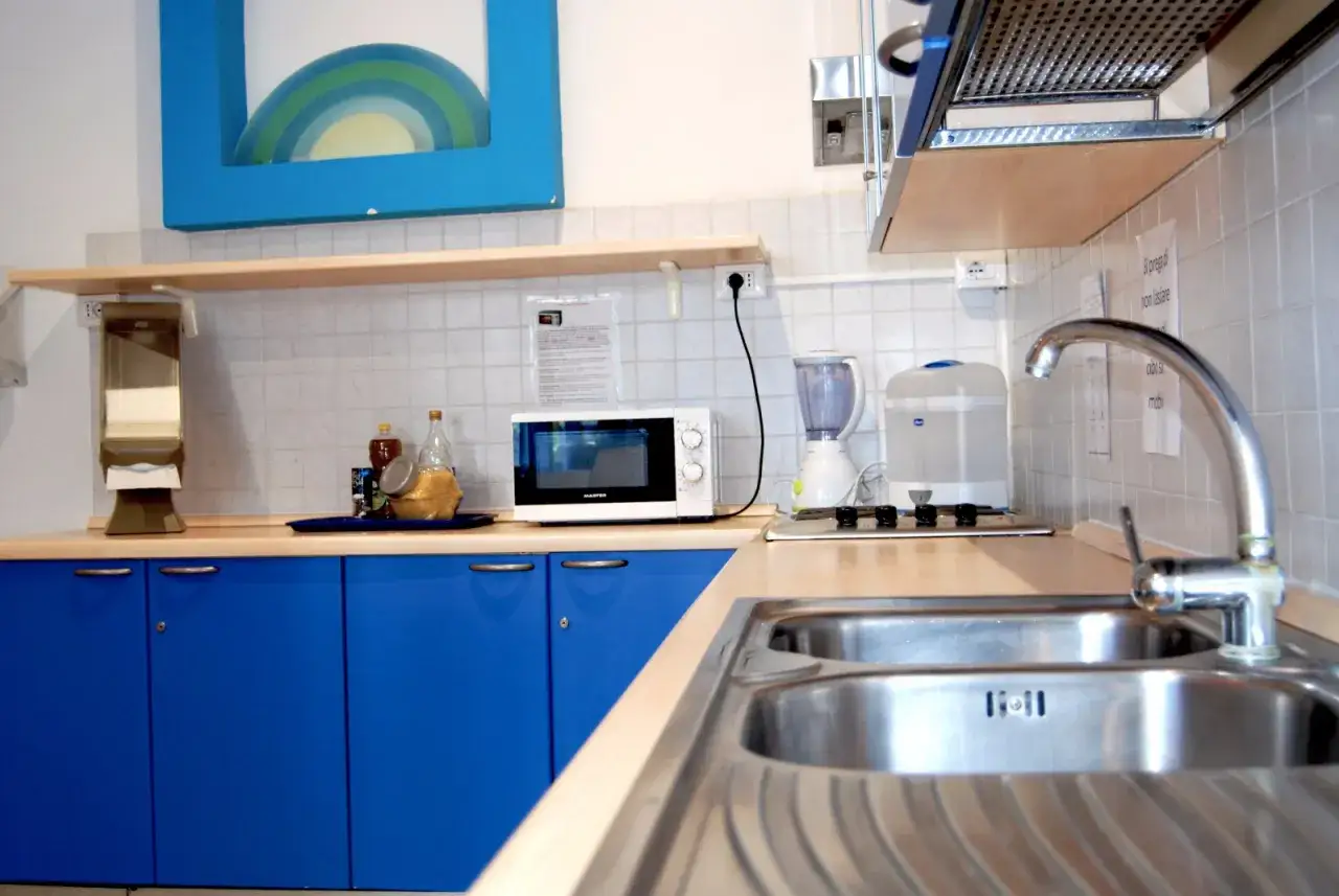 Cucina attrezzata in un hotel con biberoneria, completa di microonde, frullatore e sterilizzatore.