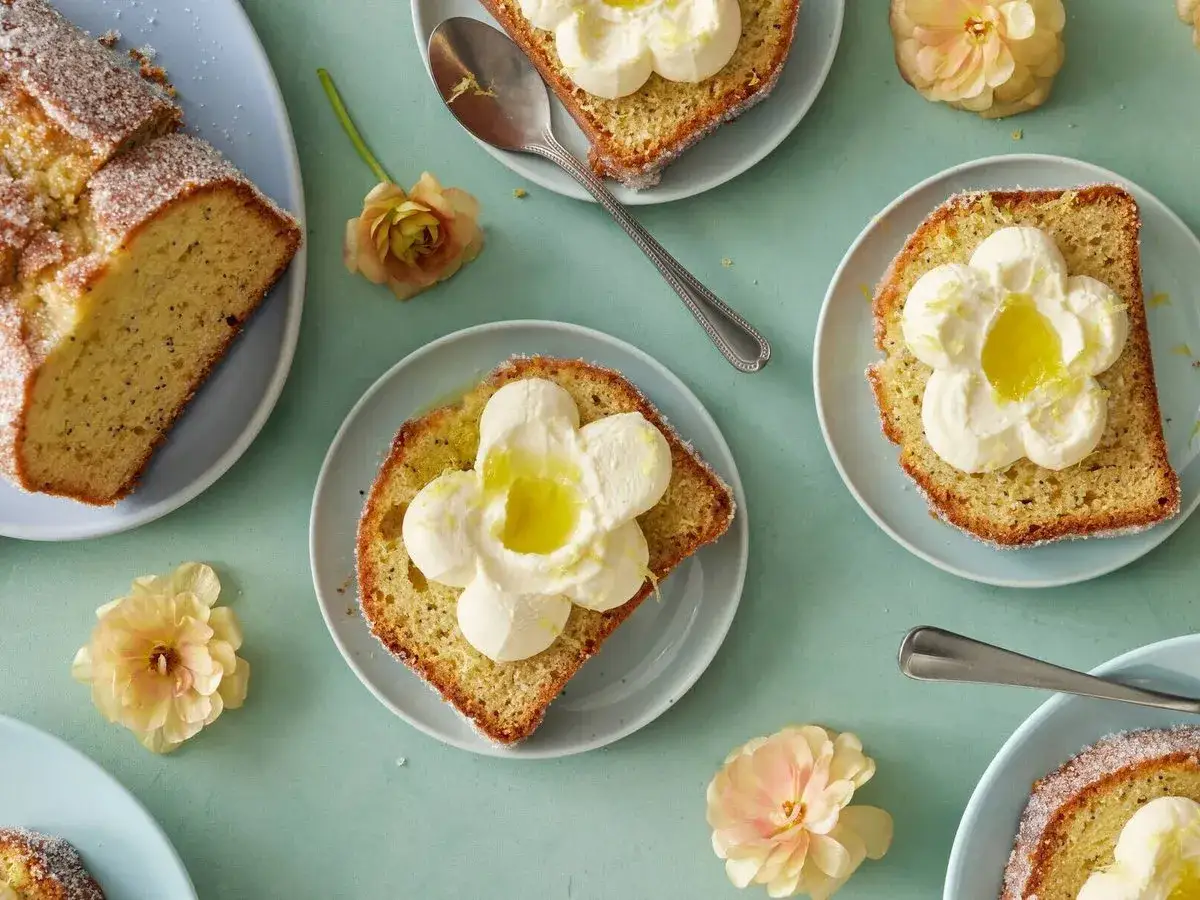 Citronkaka med fluffig gr&auml;dde och en klick syrlig lemon curd, dekorerad med blommor.