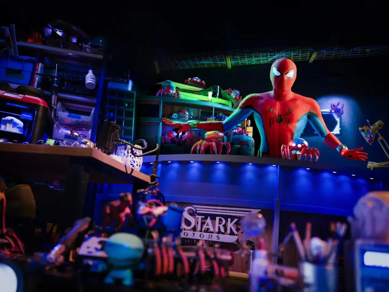 Spiderman im Avengers Campus im Disneyland Paris, umgeben von kleinen Spinnen-Robotern und Werkzeugen.